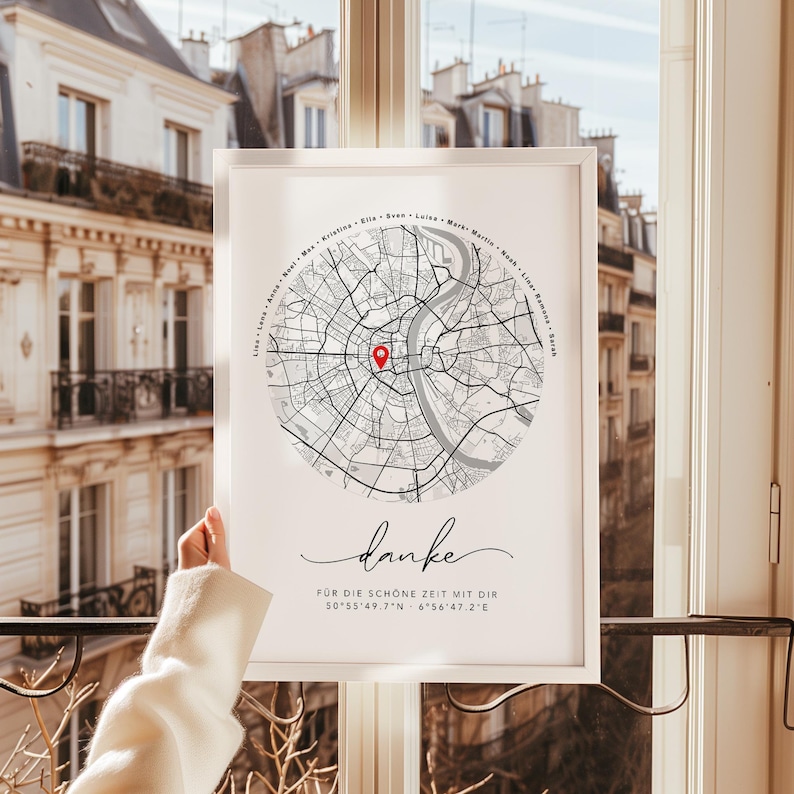 Puede incluir: Impresi&oacute;n enmarcada de un mapa de la ciudad en blanco y negro, con un marcador rojo. La impresi&oacute;n incluye la palabra "danke" en cursiva, coordenadas y texto. El marco es blanco.