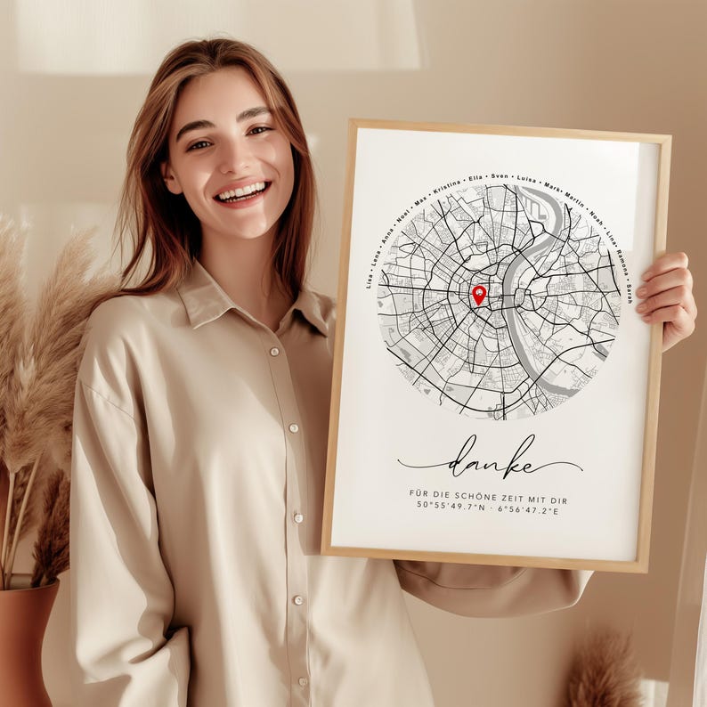 Puede incluir: Un grabado enmarcado con un dise&ntilde;o de mapa de la ciudad, un marcador rojo y la palabra "danke" en cursiva. El grabado est&aacute; en un marco de madera clara. El grabado tambi&eacute;n incluye las coordenadas 50&deg;55'49.7"N 6&deg;56'47.2"E.