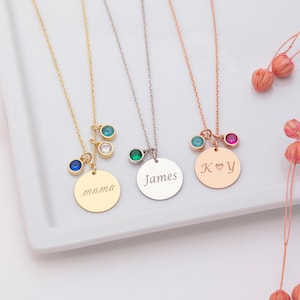 May include: Three gold, silver, and rose gold necklaces with round pendants. The pendants are engraved with the words "mama", "James", and "K♥Y". Each necklace has small colourful gemstones attached.