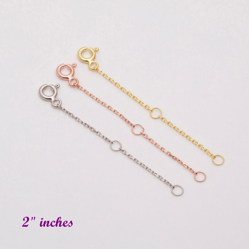 May include: Three gold chain extenders, each 2 inches long, in gold, rose gold, and silver.