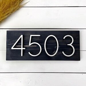 May include: A black wooden sign with white numbers reading "4503".