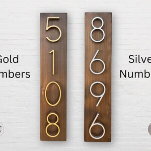 Puede incluir: Dos letreros de madera con n&uacute;meros de casa. El letrero de la izquierda tiene los n&uacute;meros 5108 en dorado. El letrero de la derecha tiene los n&uacute;meros 8696 en plateado. Ambos letreros tienen un fondo de madera marr&oacute;n oscuro.