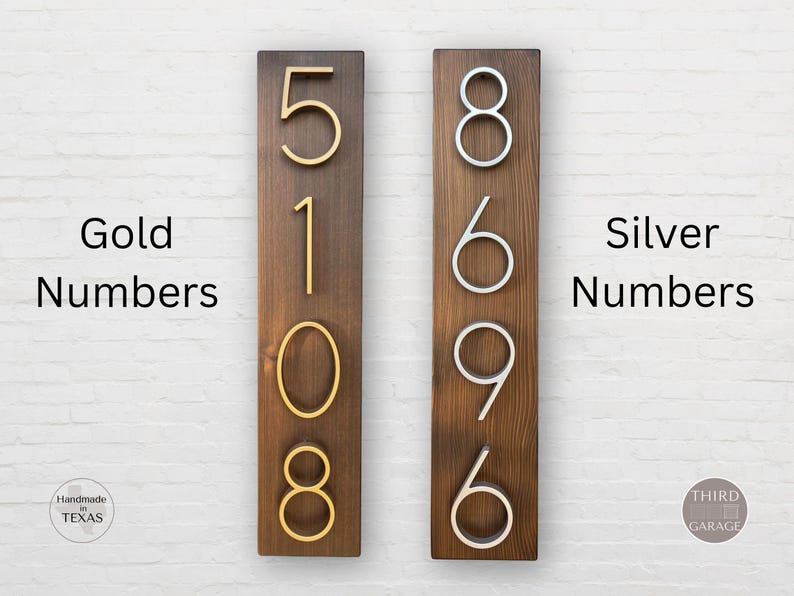 May include: Two wooden signs with house numbers. The sign on the left has gold numbers 5108. The sign on the right has silver numbers 8696. Both signs have a dark brown wood background.