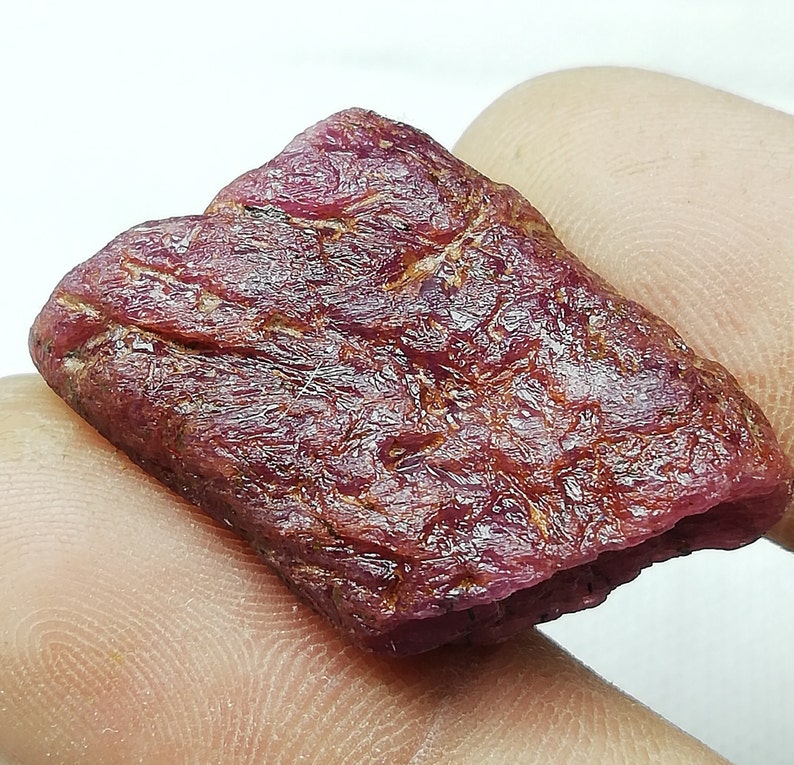 Peut inclure: Une pierre pr&eacute;cieuse de rubis rouge brute avec une couleur profonde et riche. Le rubis a une finition naturelle non polie et est un bel exemple de cette pierre pr&eacute;cieuse.