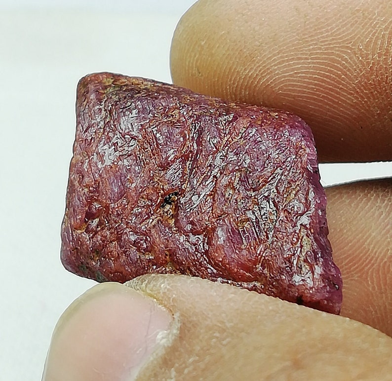 Peut inclure: Une pierre pr&eacute;cieuse de rubis rouge brute avec une couleur profonde et riche. La pierre pr&eacute;cieuse a une finition naturelle non polie et est un bel exemple de rubis brut.
