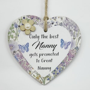 May include: A white heart-shaped wooden sign with a floral pattern and butterflies. The sign reads "Only the best Nanny gets promoted to Great Nanny".