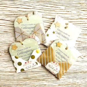 Puede incluir: Un conjunto de etiquetas de regalo y peque&ntilde;os sobres decorativos. Las etiquetas tienen forma de coraz&oacute;n y estrella, con el texto "Chance made us Colleagues". Los sobres tienen varios dise&ntilde;os y la frase "thank you!"