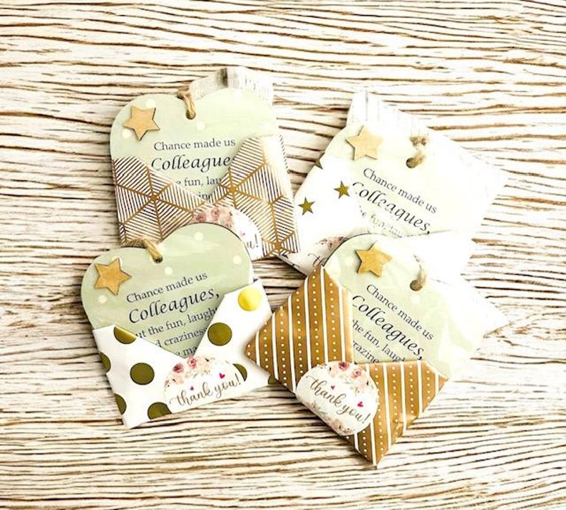 Puede incluir: Un conjunto de etiquetas de regalo y peque&ntilde;os sobres decorativos. Las etiquetas tienen forma de coraz&oacute;n y estrella, con el texto "Chance made us Colleagues". Los sobres tienen varios dise&ntilde;os y la frase "thank you!"