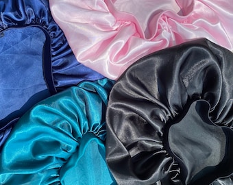 Può includere: Quattro cuffie per capelli in raso di diversi colori: blu navy, rosa, verde acqua e nero. Le cuffie sono realizzate in tessuto liscio e setoso e sono progettate per proteggere i capelli durante il sonno.