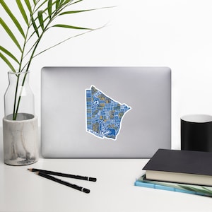 May include: A blue and yellow sticker of a map of Minneapolis, Minnesota. The map is filled with text, including neighborhood names and landmarks. The sticker is on a silver laptop.