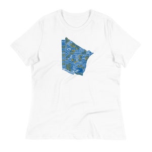 May include: White t-shirt featuring a blue and gold graphic design in the shape of a geographical area. The graphic is filled with text and shapes. The shirt has a relaxed fit and short sleeves.