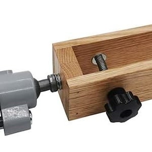 K&ouml;nnte beinhalten: Eine Holzklemmzange mit einer daran befestigten Metallklemmzange. Die Holzklemmzange hat einen Knopf an der Seite und die Metallklemmzange eine Schraube an der Seite. Die Klemmzange dient dazu, ein St&uuml;ck Holz festzuhalten.