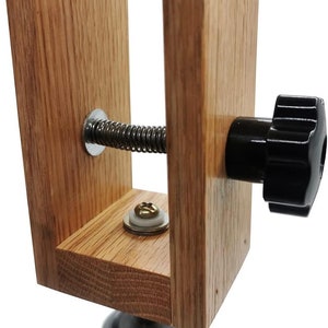 K&ouml;nnte beinhalten: Nahaufnahme eines Holzschuhspanners mit einer Feder und einem schwarzen Knopf. Der Schuhspanner ist aus hellbraunem Holz und hat eine Metallbasis.
