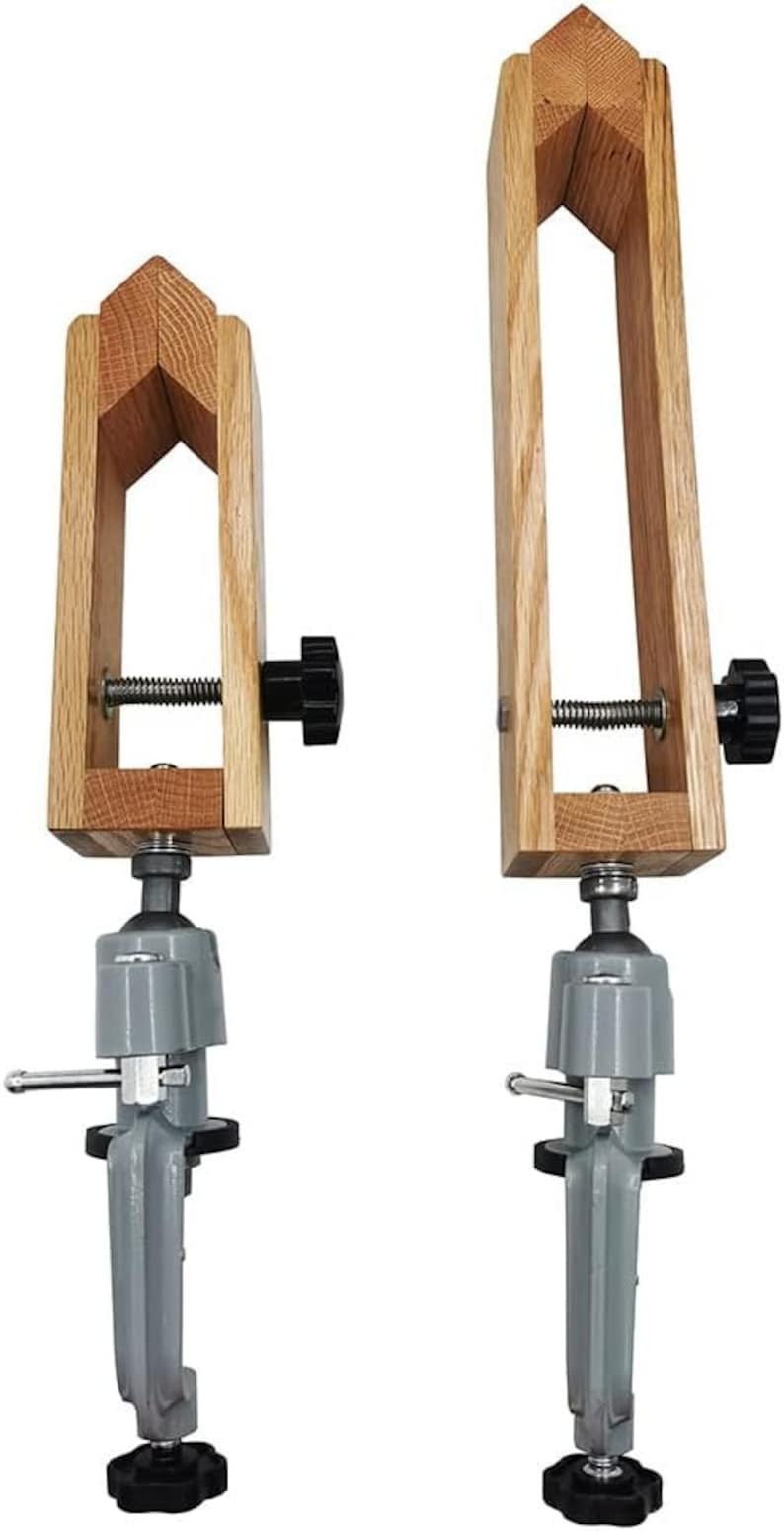 K&ouml;nnte beinhalten: Zwei Holz-Zwingen mit verstellbaren Spannkn&ouml;pfen und grauen Metallsockeln. Die Zwingen sind auf einem wei&szlig;en Hintergrund montiert.