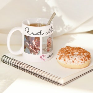 Pu&ograve; includere: Una tazza in ceramica bianca con la scritta nera "First Mother as long as I live" e due foto di un bambino. La tazza &egrave; piena di t&egrave; e un cucchiaio d'argento &egrave; appoggiato sul bordo. Un donut &egrave; appoggiato su un quaderno bianco con una rilegatura a spirale.