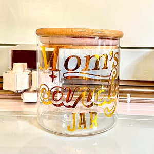 May include: A glass jar with a bamboo lid and a gold vinyl decal that says "Mom's Candy Jar".