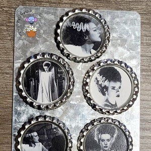May include: Set of five silver bottle cap magnets featuring black and white images of the Bride of Frankenstein from the classic horror film.