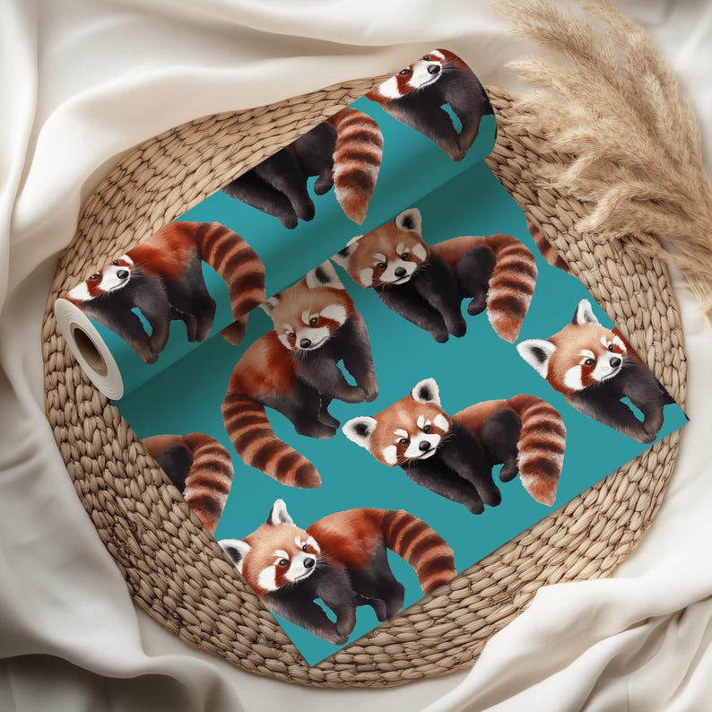 K&ouml;nnte beinhalten: Eine Rolle t&uuml;rkisfarbener Tapete mit einem sich wiederholenden Muster aus roten Pandas. Die Pandas haben rotbraunes Fell, schwarze Beine und gestreifte Schw&auml;nze. Die Tapete wird auf einem Weidenkorb pr&auml;sentiert.