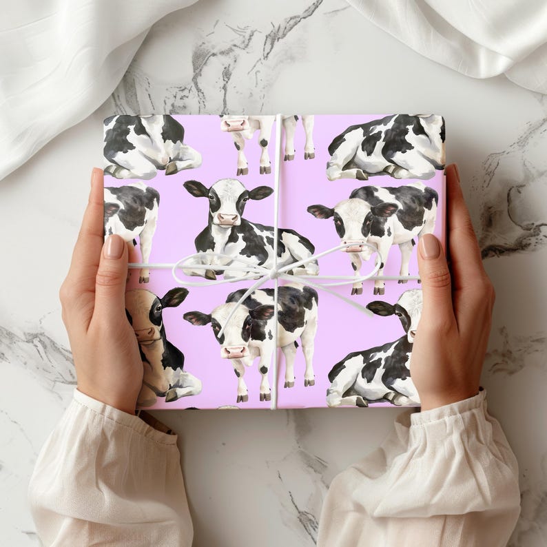 May include: A wrapped gift featuring a repeating pattern of black and white cows on a light purple background. The gift is tied with white string. The overall theme is farm animals.