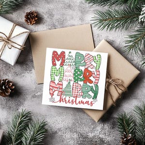 Könnte beinhalten: Eine quadratische Weihnachtskarte mit den Worten "MERRY CHRISTMAS" in bunten, gemusterten Buchstaben. Die Karte liegt auf einem braunen Umschlag, umgeben von Geschenken, Tannennadeln und Tannenzapfen.