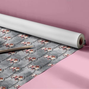 May include: A roll of wrapping paper featuring a repeating pattern of cartoon cows with brown and white spots on a gray textured background. The text "DON'T BE MOODY B*TCH" is printed in a circular arrangement around each cow illustration.
