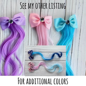 May include: Three hair clips with bows and attached hair extensions. The bows are purple, pink, and blue. The hair extensions are purple, pink, and blue. The text "See my other listing for additional colors" is at the bottom of the image.