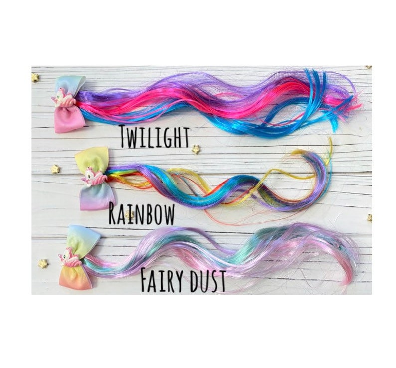 May include: Three colorful hair extensions with unicorn clips. The extensions are labeled "Twilight", "Rainbow", and "Fairy Dust".