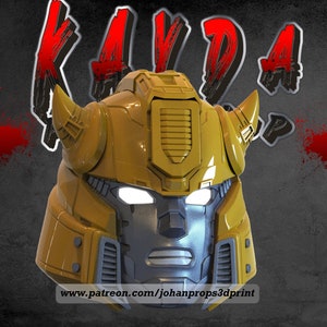 May include: A 3D printed yellow and gray robot head with a large, detailed horn on each side. The robot's eyes are glowing white. The text "www.patreon.com/johanprops3dprint" is printed below the robot's head.