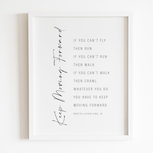 Puede incluir: Un marco blanco con la frase "Keep Moving Forward" en escritura cursiva. El marco contiene una cita de Martin Luther King, Jr., presentada en un diseño limpio y moderno. La cita es un mensaje de ánimo.