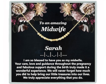 May include: A gold necklace with a beaded charm that says "To an amazing Midwife" and a name, "Sarah". The necklace is displayed on a black background with a floral design.