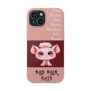 May include: A pink phone case with a cartoon pink creature with big eyes and the text "This Phone Has Been Marked Safe From Bad Hair Days".