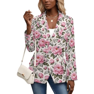 Pode incluir: Blazer de abotoamento duplo com um padrão floral de peónias cor-de-rosa e folhas verdes sobre um fundo branco. O blazer tem lapelas e botões prateados. Uma bolsa branca com fecho dourado é visível.
