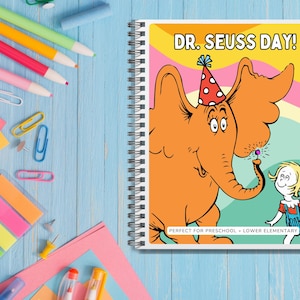 May include: A spiral bound notebook featuring a colourful illustration of an elephant wearing a party hat and a girl holding a balloon. The cover reads "Dr. Seuss Day!" and "Perfect for Preschool - Lower Elementary".