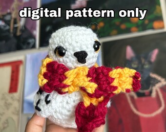 Könnte beinhalten: Weiße gehäkelte Eule mit einem rot-gelben Schal. Der Text "digital pattern only" ist im Bild sichtbar.