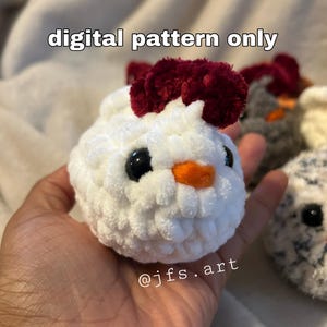 May include: A white crocheted chick with a burgundy pom-pom on its head. The chick has black eyes, an orange beak, and a white fluffy body. The image includes the text "digital pattern only" and "@jfs.art".