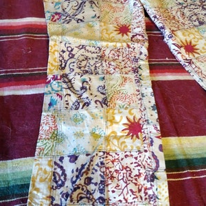 May include: A pair of patchwork pants with a multi-colored floral and paisley design. The pants are made of a light-weight fabric and have a relaxed fit.
