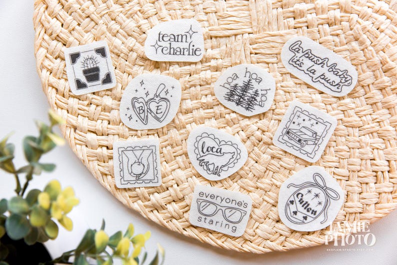 May include: A collection of ten white stickers with black line art designs, including text like team charlie, la push baby, it's la push, loca, everyone's staring, and cullen, alongside illustrations of a cactus, locket, trees, car, apple, and glasses.