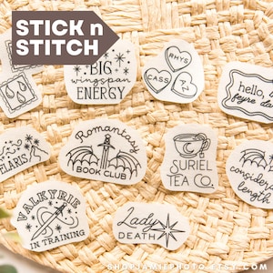 May include: A collection of ten white adhesive embroidery stabilizer patches featuring black line art illustrations and text including Big Wingspan Energy, Romantasy Book Club, Suriel Tea Co, Valkyrie In Training, Lady Death, and Velaris.