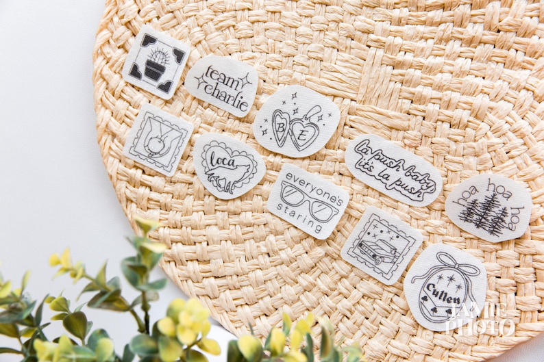 May include: A collection of ten individual white stickers with black line art designs, including text such as team charlie, la push baby it's la push, everyone's staring, and cullen, alongside illustrations of a cactus, wolf, locket, car, and trees.