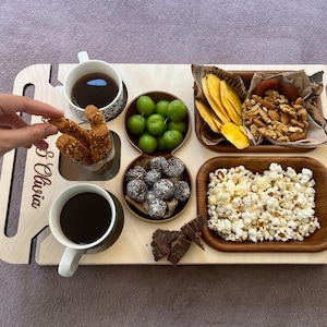 Custom wooden serving tray used as a snack bar and charcuterie board on sofa arm