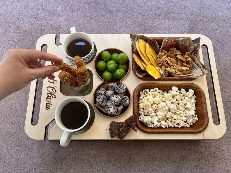 Custom wooden serving tray used as a snack bar and charcuterie board on sofa arm