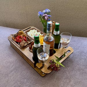 Movie night snackbox on sofa with wine bottle, glasses, and remote control