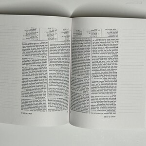 May include: A close-up of an open book with white pages and black text. The book has tabs on the side with the names of different books of the Bible, including 1 Nephi, 2 Nephi, Jacob, Enos, Jarom, Omni, Words of Mormon, Mosiah, Alma, Helaman, 3 Nephi, Ether, Moroni, and Mormon.