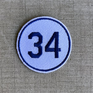 May include: A white circle with a blue outline and the number 34 in blue inside.