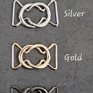 Pode incluir: Tr&ecirc;s fivelas entrela&ccedil;adas de 2,5 cm em prata, ouro e bronze.