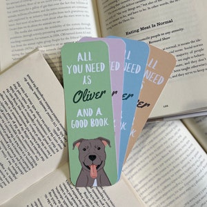 May include: Set of four colorful bookmarks featuring a dog with the text "All you need is Oliver and a good book".