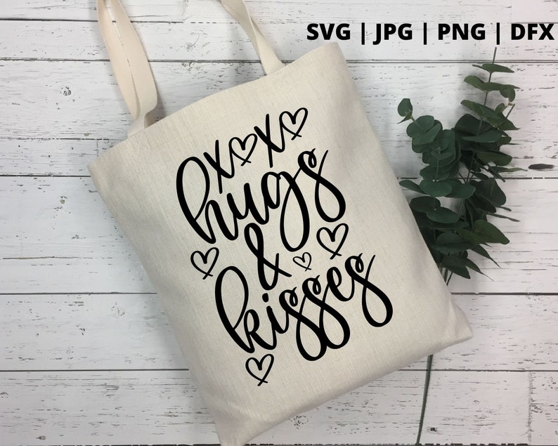 K&ouml;nnte beinhalten: Eine wei&szlig;e Einkaufstasche mit schwarzem Text, der "Hugs & Kisses" mit Herzen um den Text herum lautet.