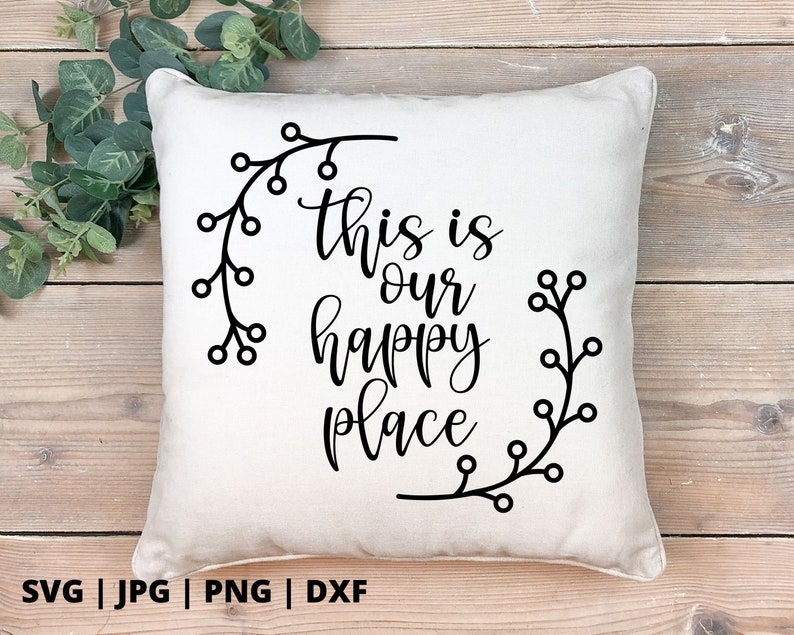 以下が含まれることがあります： 黒い文字で「This is our happy place」と書かれた白いクッションと、黒い花の模様が描かれています。