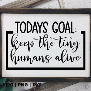 K&ouml;nnte beinhalten: Ein gerahmtes Schild mit wei&szlig;em Hintergrund und schwarzem Text, der "TODAYS GOAL: keep the tiny humans alive" lautet.