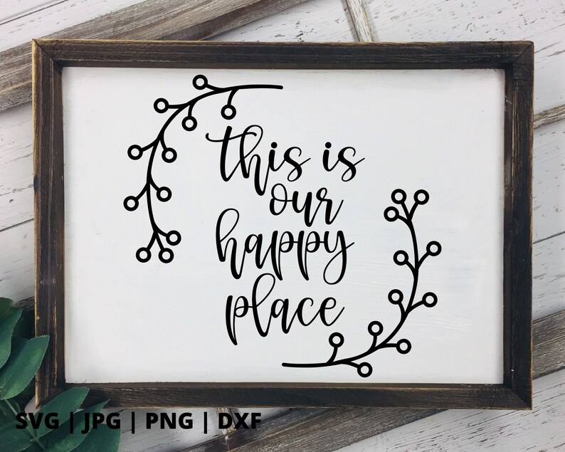 以下が含まれることがあります： 「This is our happy place」と書かれた、黒い文字と花の模様が描かれた白い看板です。